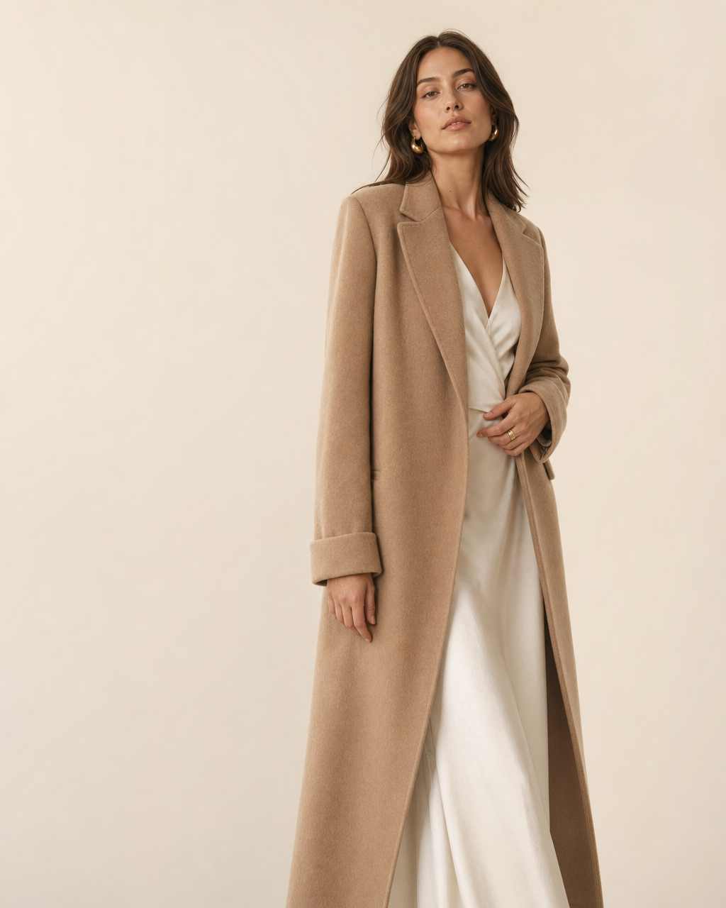 VYRON editorial — an elegant woman in a tailored camel coat over an ivory dress